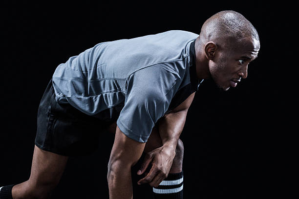 istock Determined sportsman bending while playing rugby 488763274
