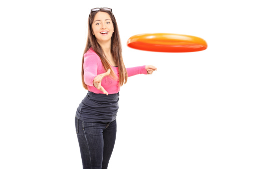 Beautiful woman throwing a Frisbee disk isolated on white background