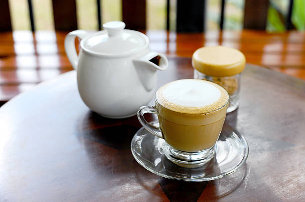 istock hot coffee cappuccino  in cup on wood table 488765356