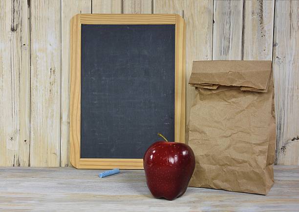 istock brown lunch bag with apple and chalkboard 488766512