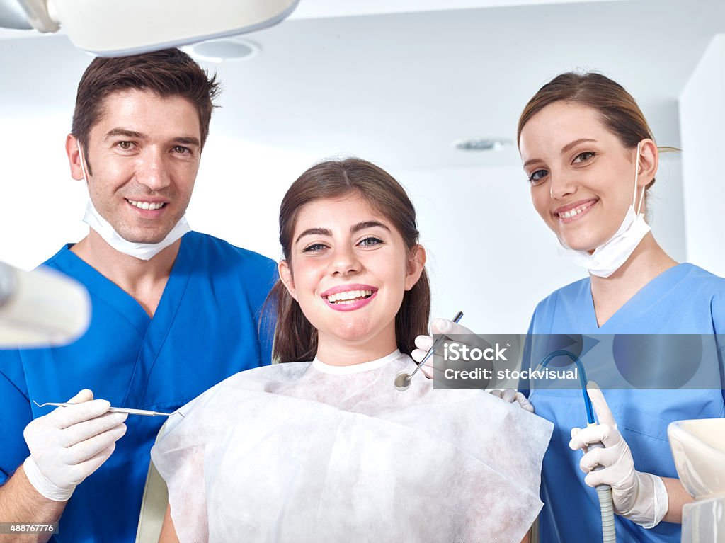 Dentist, assistant and young woman similing for the camera Dentists and young woman Dental Health Stock Photo