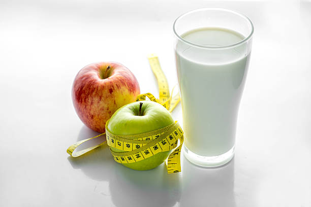 istock Glass of milk with apple isolated on white, selective focus 488768316