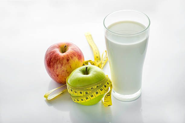 istock Glass of milk with apple isolated on white, selective focus 488768454