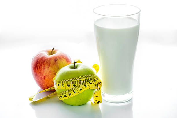 istock Glass of milk with apple isolated on white, selective focus 488768526