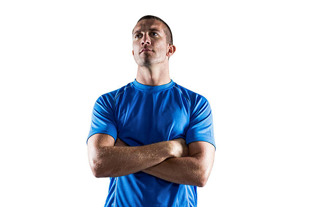 Confident rugby player looking away with arms crossed