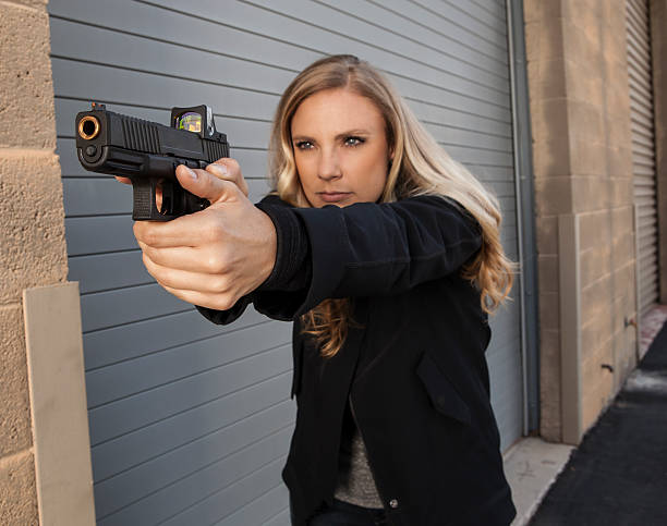 istock Female shooter aiming gun. 488770054