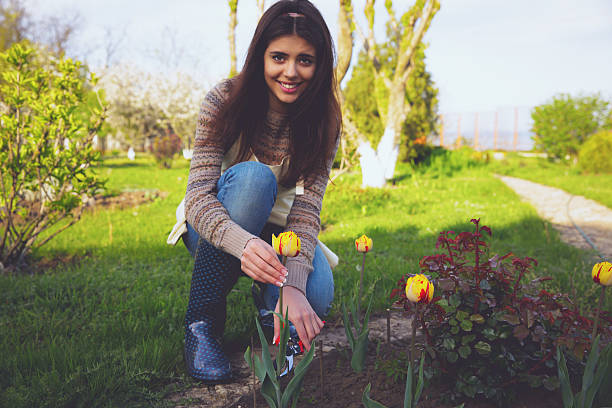 istock cheerful woman cutting the flowers 488782505