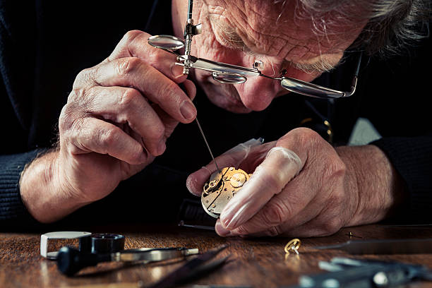 nahaufnahme eines portraits eines watchmaker bei der arbeit - präzision stock-fotos und bilder