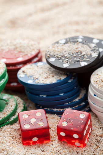 Poker's cubes and chips photographed on sand