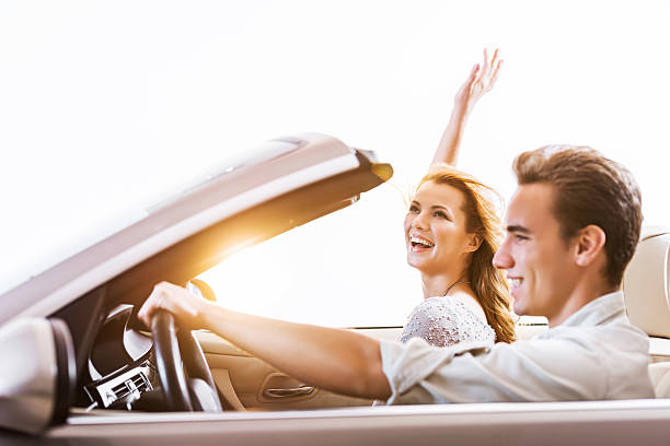 istock Happy couple in a convertible car at sunset. 488787253