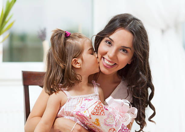 madre e figlia - mothers day mother kissing child foto e immagini stock