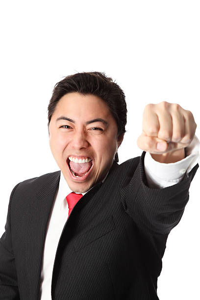 Number 1! Businessman with a raised fist, wearing a suit and tie. White background. punching one person shaking fist fist stock pictures, royalty-free photos & images