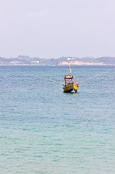 Fishing boat in beautiful ocean near coastline of Sri Lanka, Ceylon. Vertical image