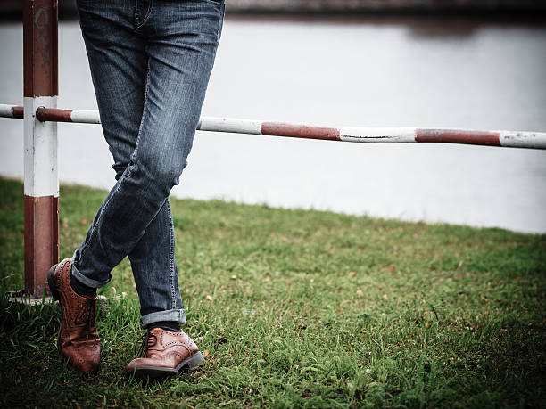 Autumn fashion, foot wear. Male legs in jeans and boots outdoor