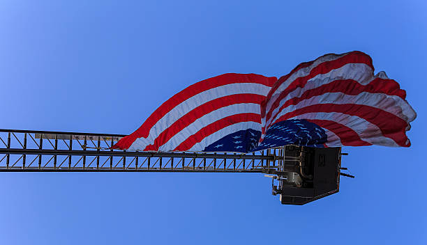 istock American Flag on crane blowing in wind on clear day 488794302