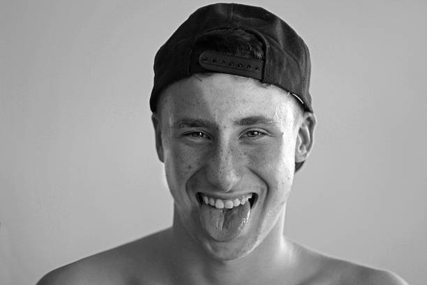 Teenager boy sticking out his tongue stock photo