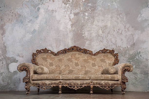 antique canapé contre fond de vieux stuc - fauteuil baroque photos et images de collection