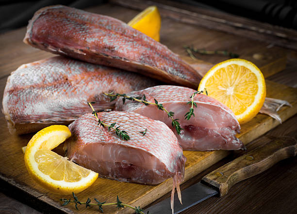 istock Sea bass with lemon on wooden board 488800957