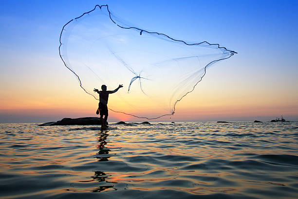istock throwing fishing net during sunrise, Thailand 488802495