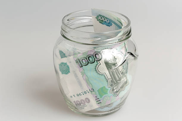 istock Money in open glass jar on gray background 488802845