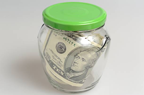 istock Closed glass jar full of banknotes on gray background 488802847