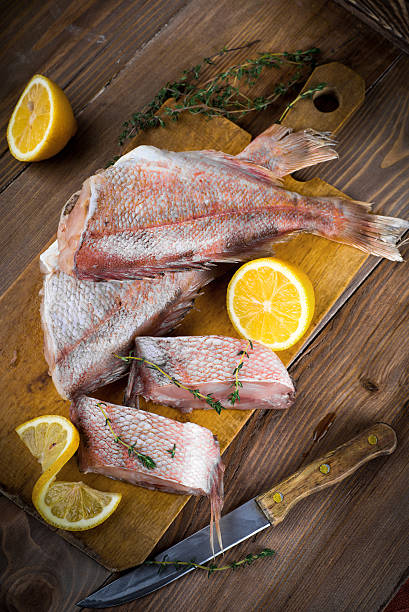 istock Sea bass with lemon on wooden board 488803511