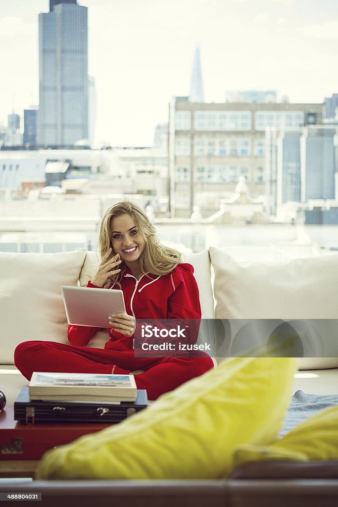 Relax in the morning Young woman sitting on sofa at home and using a digital tablet in the morning. Apartment Stock Photo
