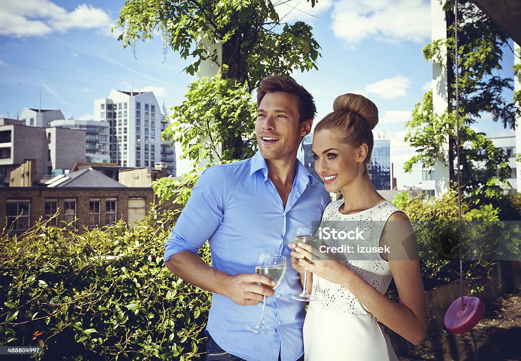 Romantic couple Outdoor portrait of affectionate couple embracing and looking away with cityscape in the background. Couple - Relationship Stock Photo