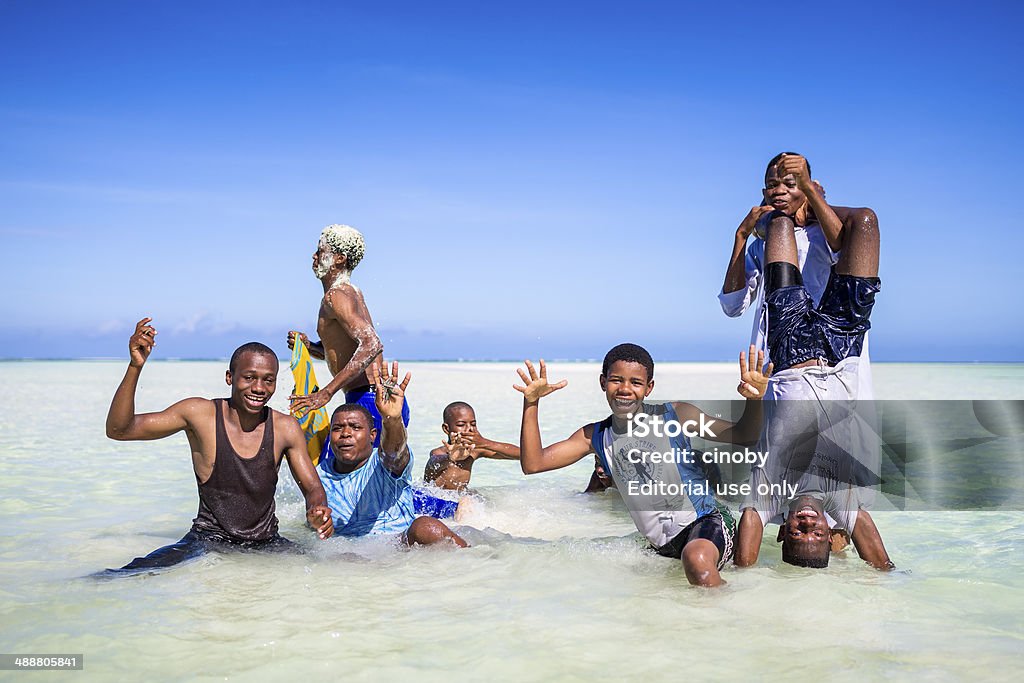 Young group of men on beach of Zanzibar Zanzibar, Tanzania - October 12, 2013: Group of young men posing in the water on the beach of fisherman's village Pwani Mchangani on Zanzibar. Activity Stock Photo