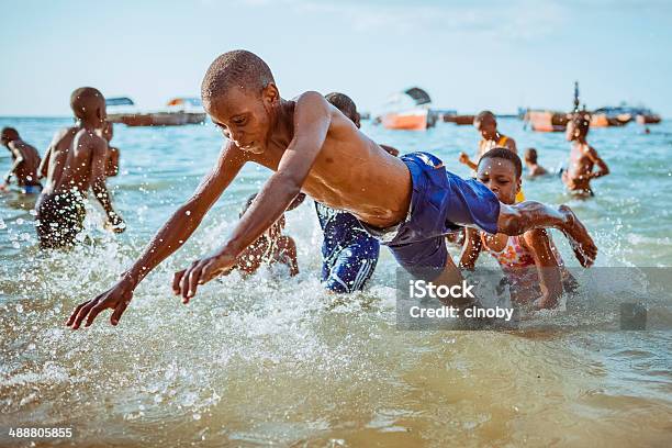 Playing Kids On The Beach Of Stone Town Zanzibar Stock Photo - Download Image Now - Child, Jumping, African-American Ethnicity