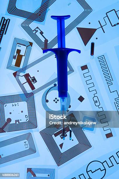 Rfid Implantation Syringe And Rfid Tags Stock Photo - Download Image Now - Accessibility, Blue Background, Colored Background