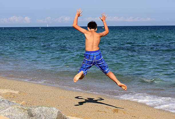 istock Boy jumping on the sea beach 488807037