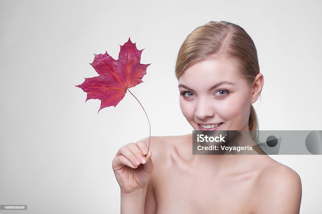 Cuidados com a pele. Retrato de jovem garota com folha vermelha. - Foto de stock de Outono royalty-free