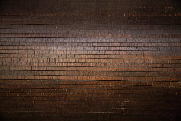 Painted, antique textured, worn dark piece of wood planks. Lines and fractures of varying thicknesses and tones run through the image. Directly above view.