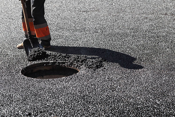 istock Asphalting, worker with shovel near sewer manhole 488820216