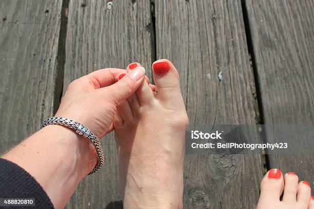 Lady Checking Between Her Toes Stock Photo - Download Image Now - 2015, Athlete's Foot, Barefoot