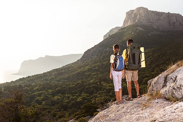 istock Couple looking at sunrise from mountain 488821252