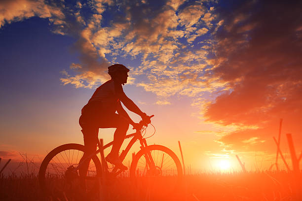 istock Silhouette of a biker and bicycle on sky background. 488826312