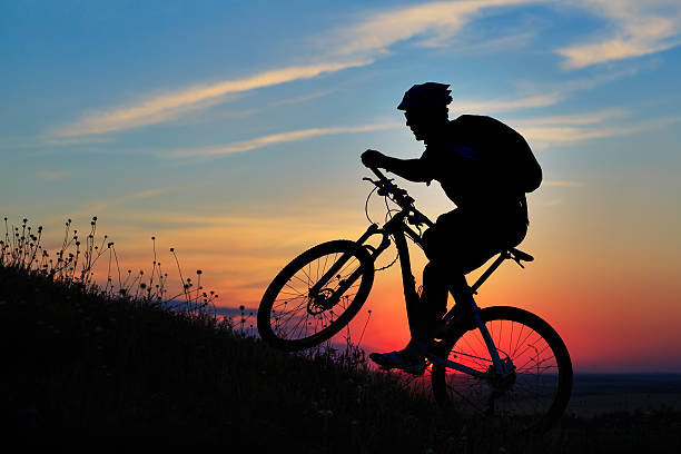istock Silhouette of a biker and bicycle on sky background. 488826502
