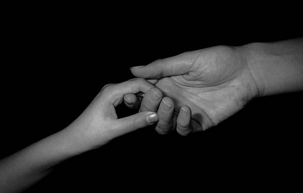 istock mother holding child's hand, black and white image. 488826575