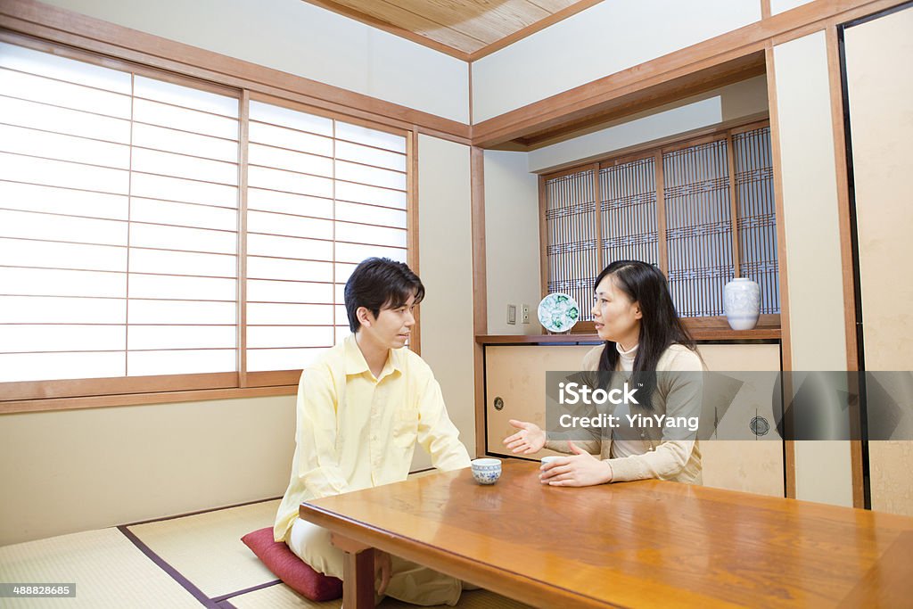 Japanese Family Couple Discussing Serious Subjects A Japanese young couple having a serious discussion in a traditional Japanese home. Married Stock Photo