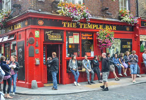 Dublin, Irelan - July 11, 2011: People sit outside the famous Temple Bar, established in 1840 and located in the Temple Bar district of Dublin, Ireland.