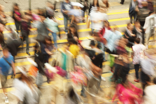 Crowd of people crossing the street, high angle view and motion blur.