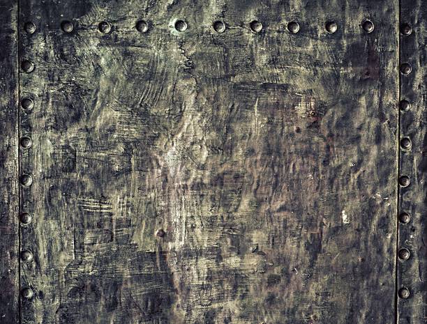 istock Grunge black metal plate with rivets screws background texture 488830117