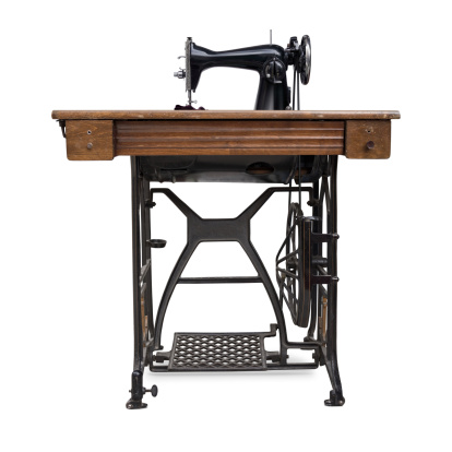 Old treadle sewing machine, isolated on white background.