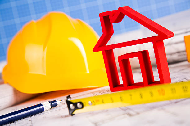 istock Architectural project and Yellow helmet and house model 488838876