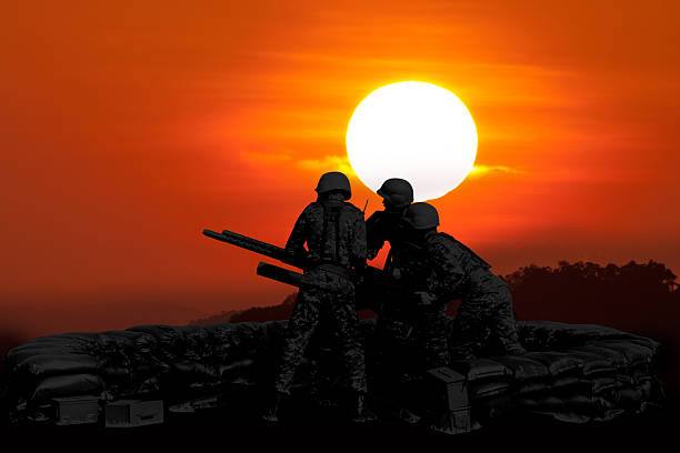 istock Anti Aircraft fire machine gun and three soldier in silhouette 488840030