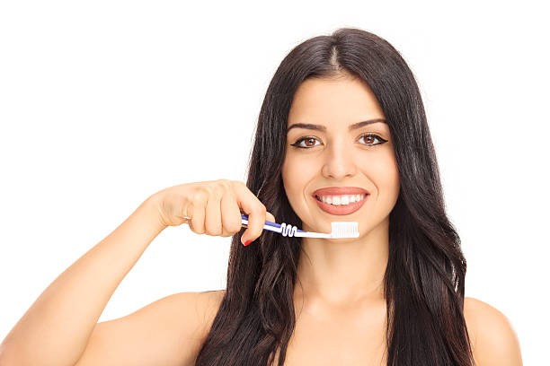 istock Beautiful young woman brushing her teeth 488842476