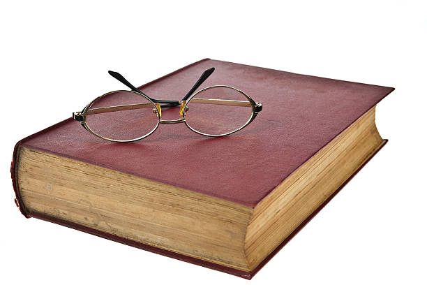 istock Old books with eye glasses isolated on white background 488843030