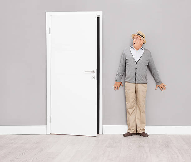 istock Scared senior gentleman hiding against a wall 488843616